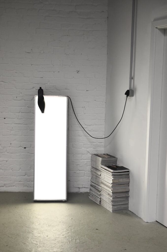 Room corner with stacked magazines and lamp for photography